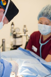 Using a stethoscope to monitor the heart during surgery